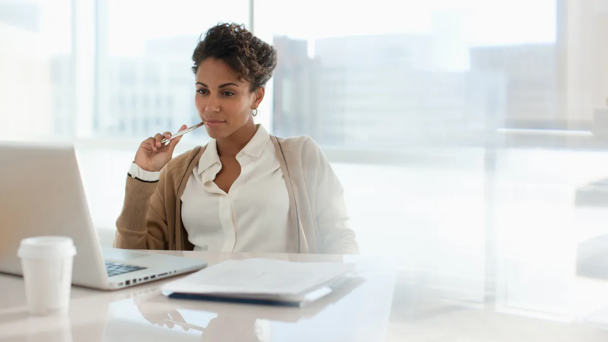 A lawyer looks at their laptop while sitting in an office