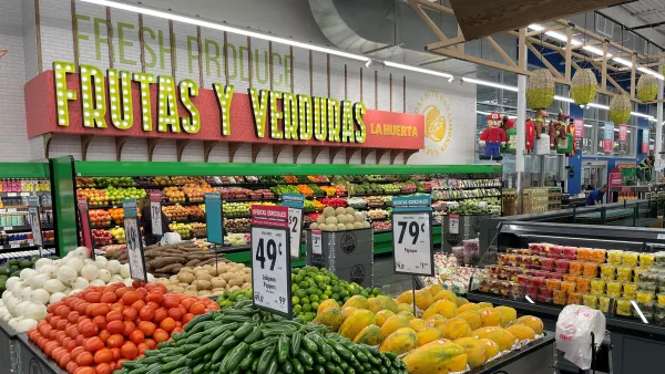 Interior shot of a Hispanic grocery store's produce section with "Fruits and Vegetable" written out in Spanish and English on the wall