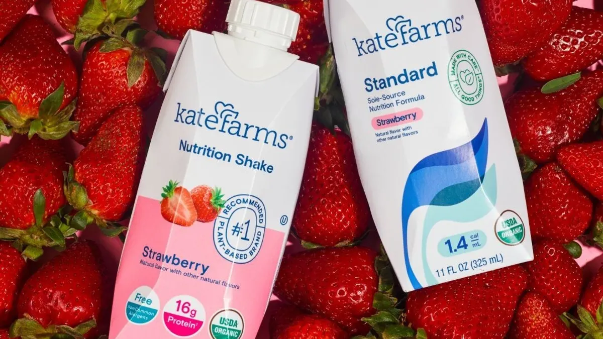 A photo of nutritional shakes are seen against a backdrop of strawberries