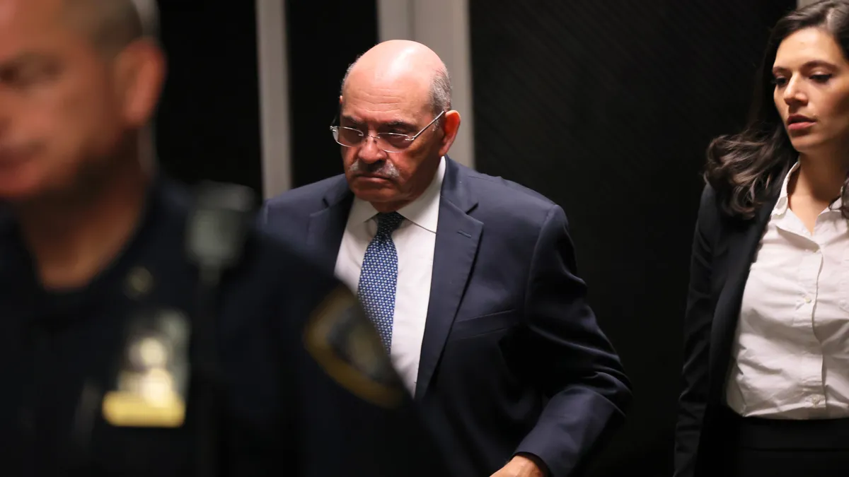 The image shows Allen Weisselberg leaving a New York City courtroom in November 2022.