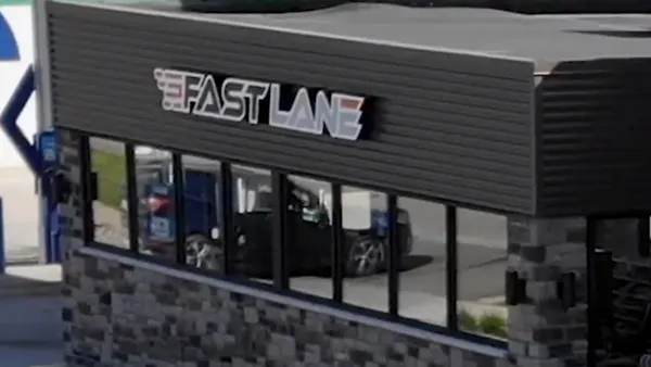 A photo of the exterior of a shop. A sign above the windows of the building says Fast Lane in black, red and white.