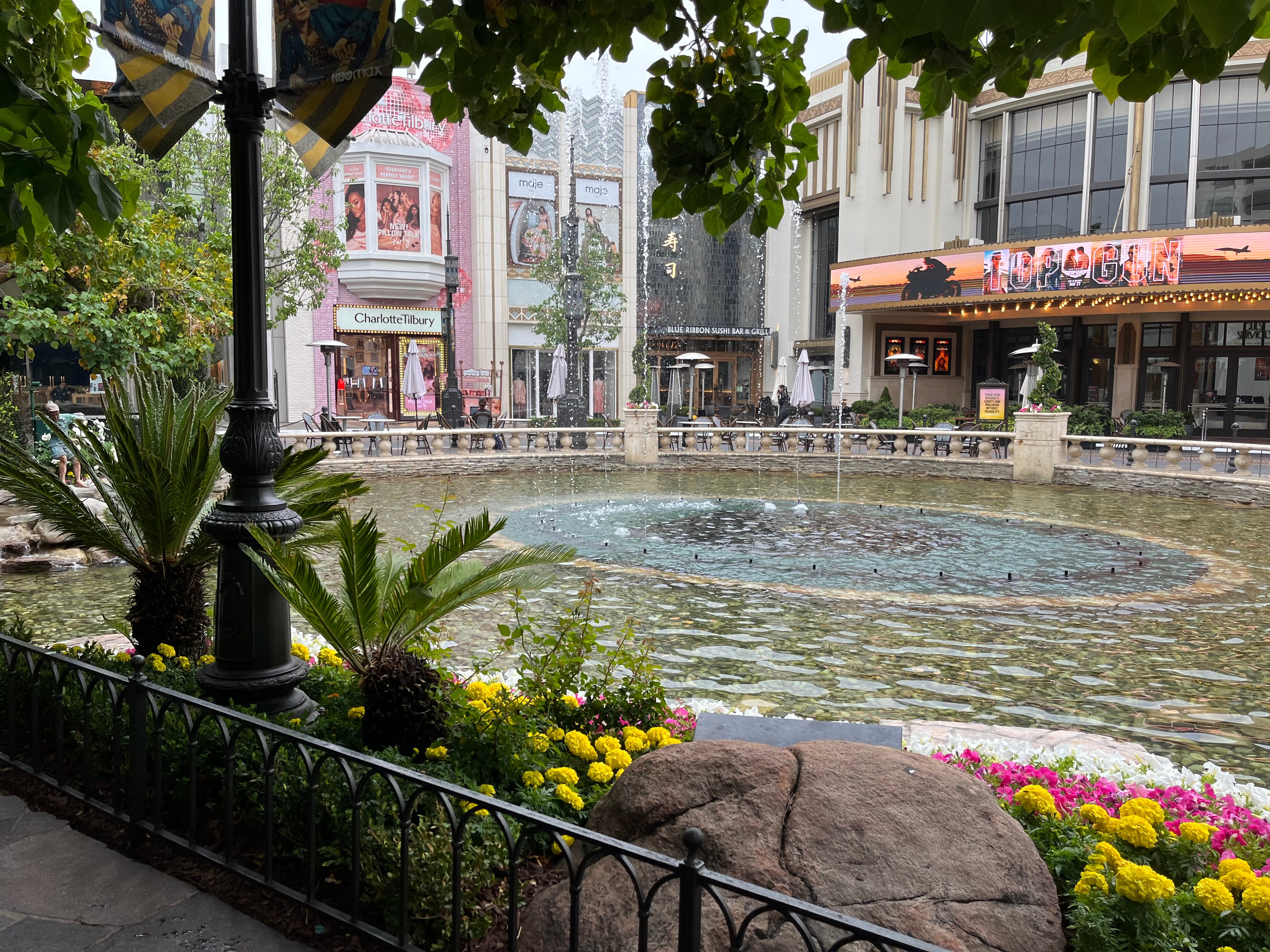 A fountain with several stores in the background at The Grove shopping center in Los Angeles.