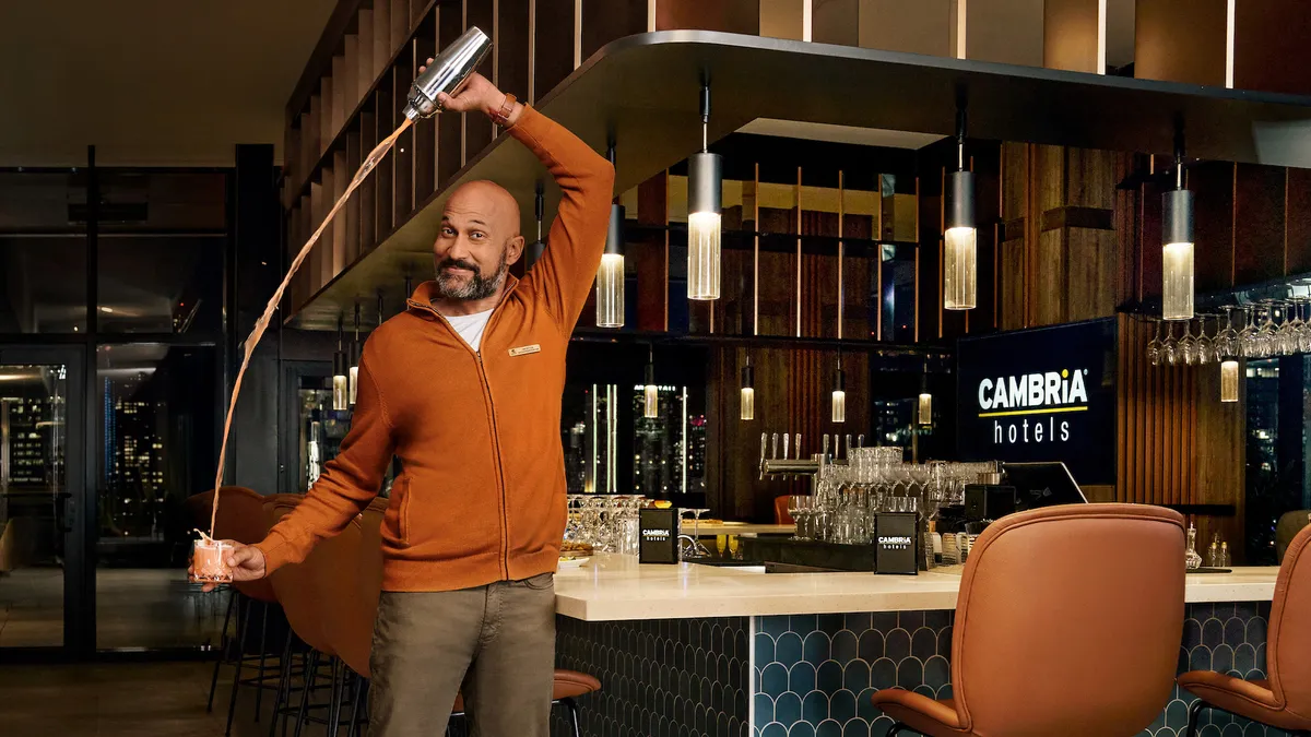 Actor Keegan-Michael Key pours a cocktail at a Cambria Hotels bar in a marketing campaign image for Choice Hotels International.