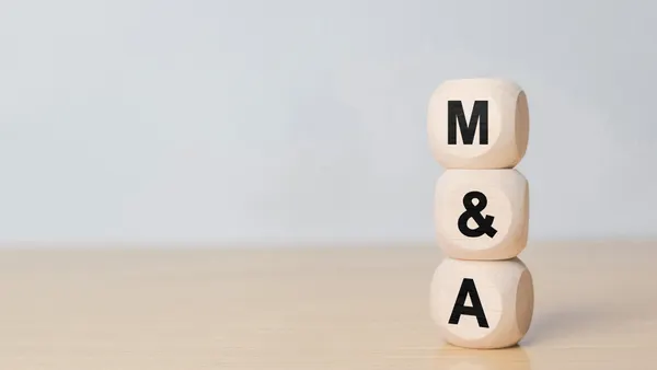 Three stacked wooden cubes on the right side of the frame read "M&A"