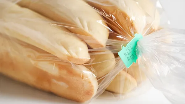 A close-up image of a clear plastic bag containing several hot dog buns.