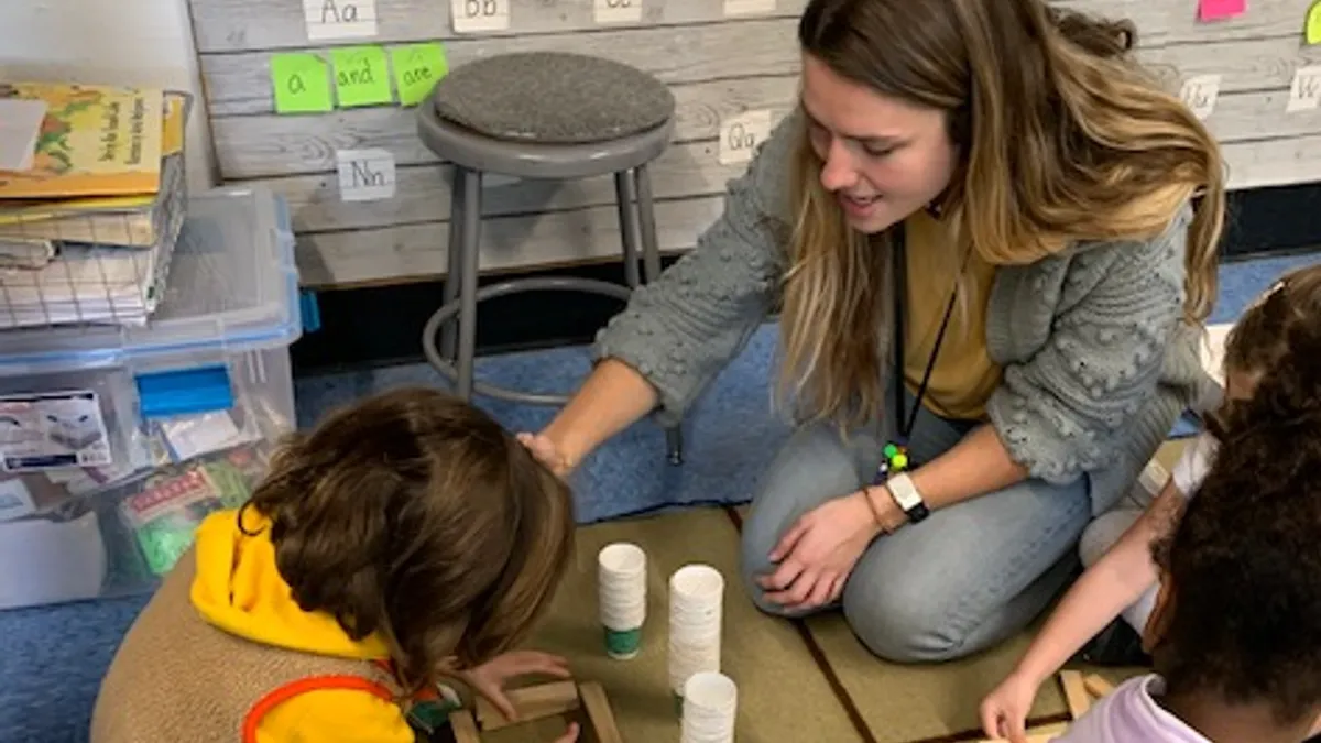 High Tech Elementary Explorer teacher apprentice Addy Rigdon works with kindergartner.