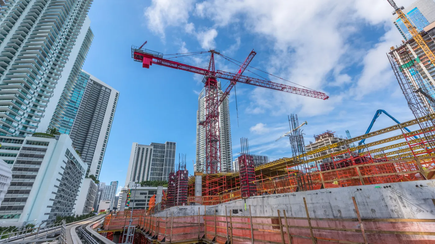 A crane looms over a jobsite in a major urban setting.