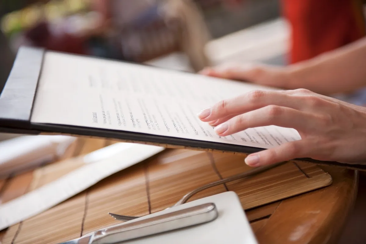 An image of a woman holding a menu