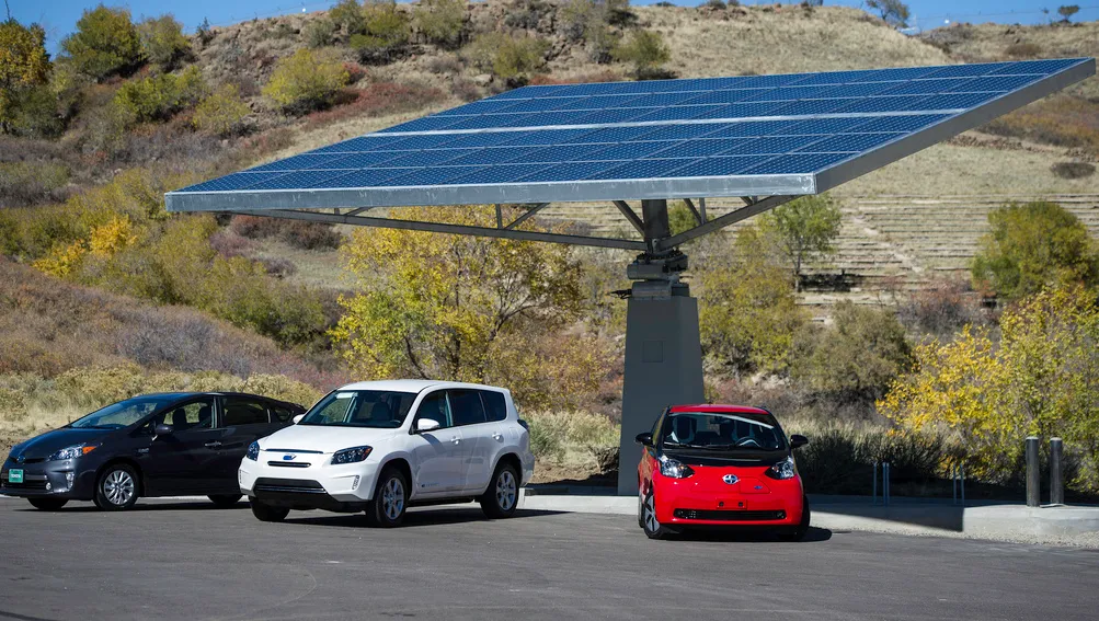 Image shows 3 cars under a solar canopy electric charger.