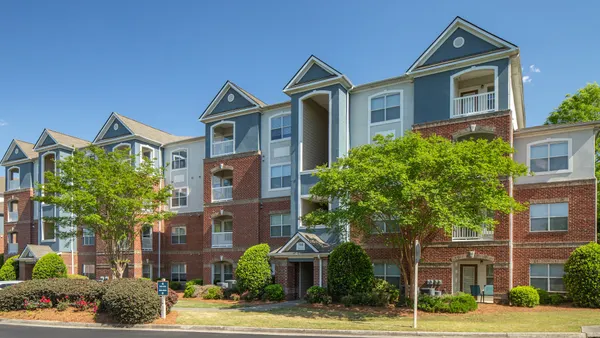 A garden-style apartment community with trees in front
