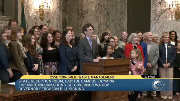 Washington Gov. Bob Ferguson poses with a crowd of people in Olympia after signing a bill