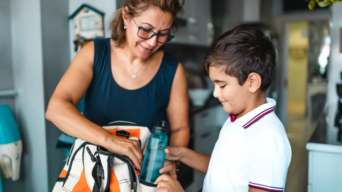 Single Mother helping her son get ready for school