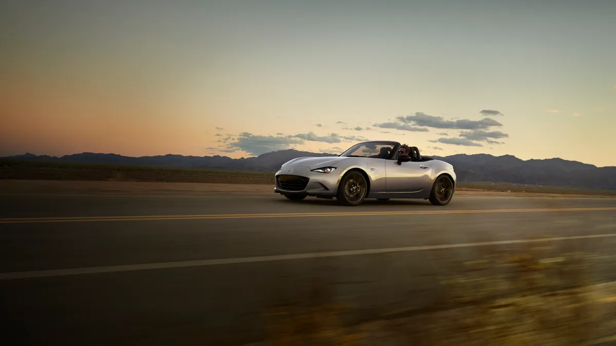 A 2024 Mazda MX-5 driving on a public road.