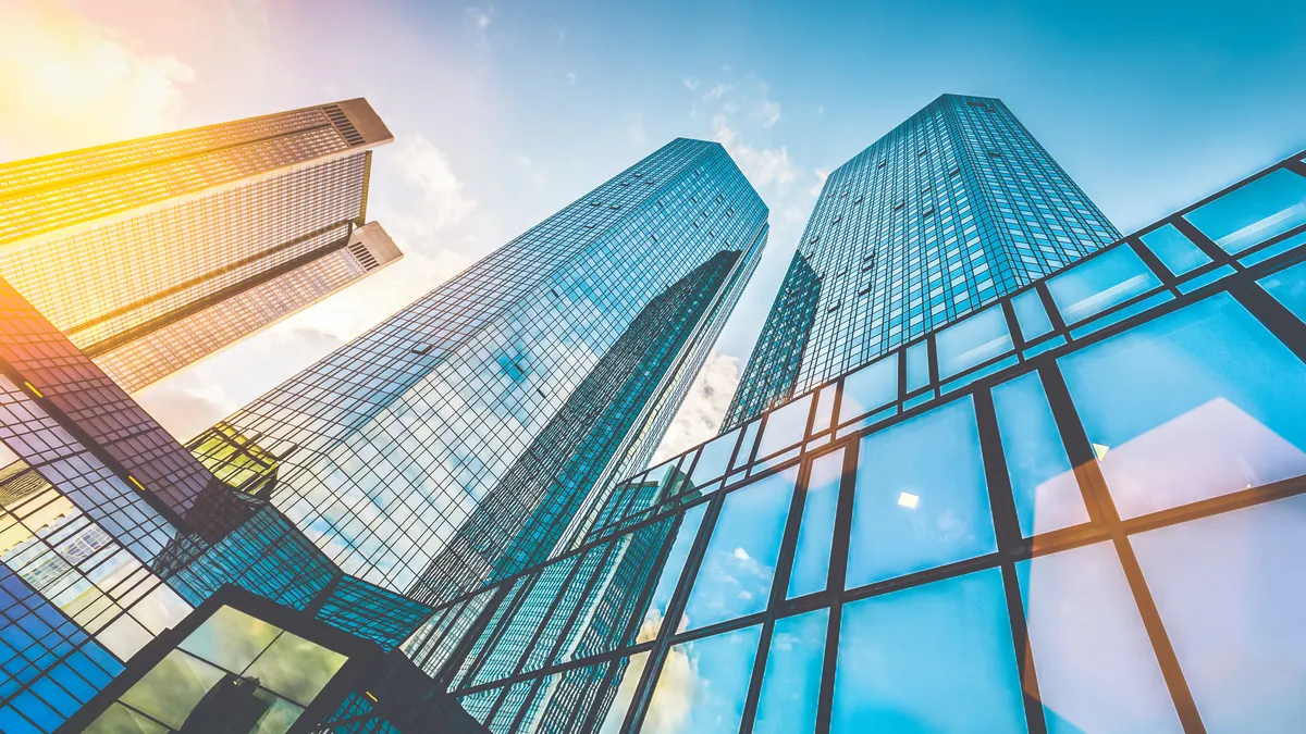 Modern skyscrapers in business district at sunset with lens flare effect
