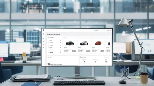 A computer display on an office desk showing a simulated OnStar Fleet Intelligence user interface.
