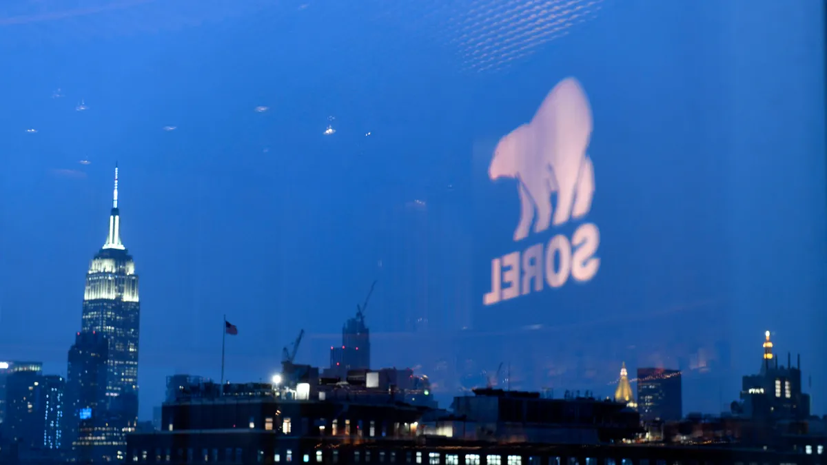 The Sorel logo is seen reflected in a window, which shows the skyline of New York City.