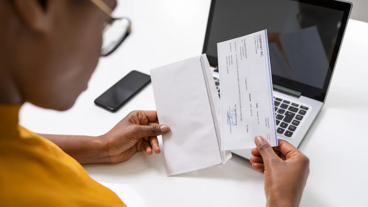 American African Holding Paycheck Or Payroll Check