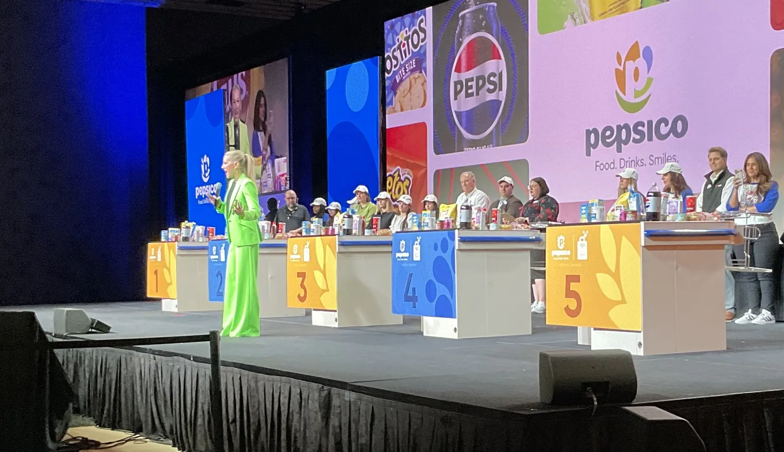 People on a stage in front of a sign that says "PepsiCo."