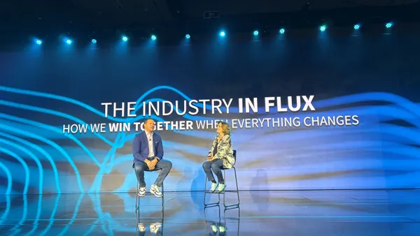 man and women sit on chairs on a keynote stage