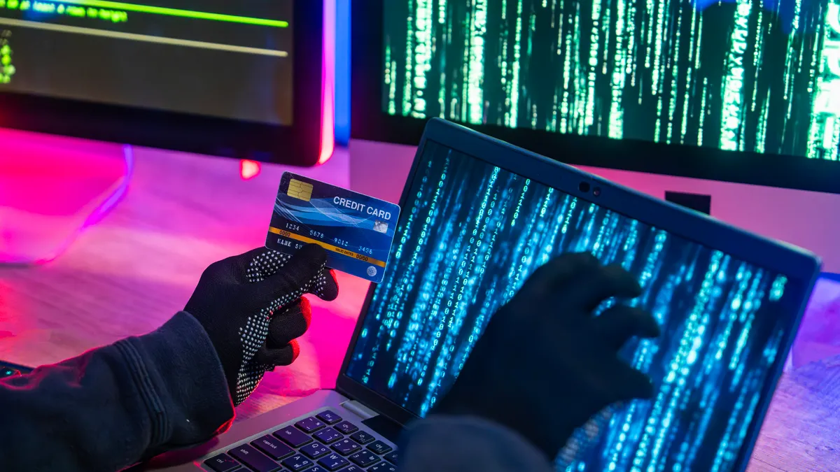 Hacker Using Laptop and Credit Card for Cybercrime Activities