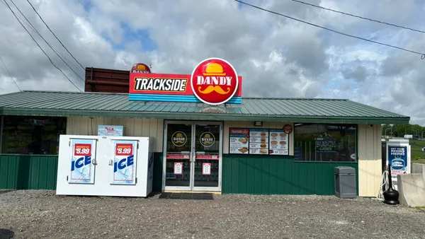 A photo of the exterior of a store. A sign above the door says "Trackside Dandy."
