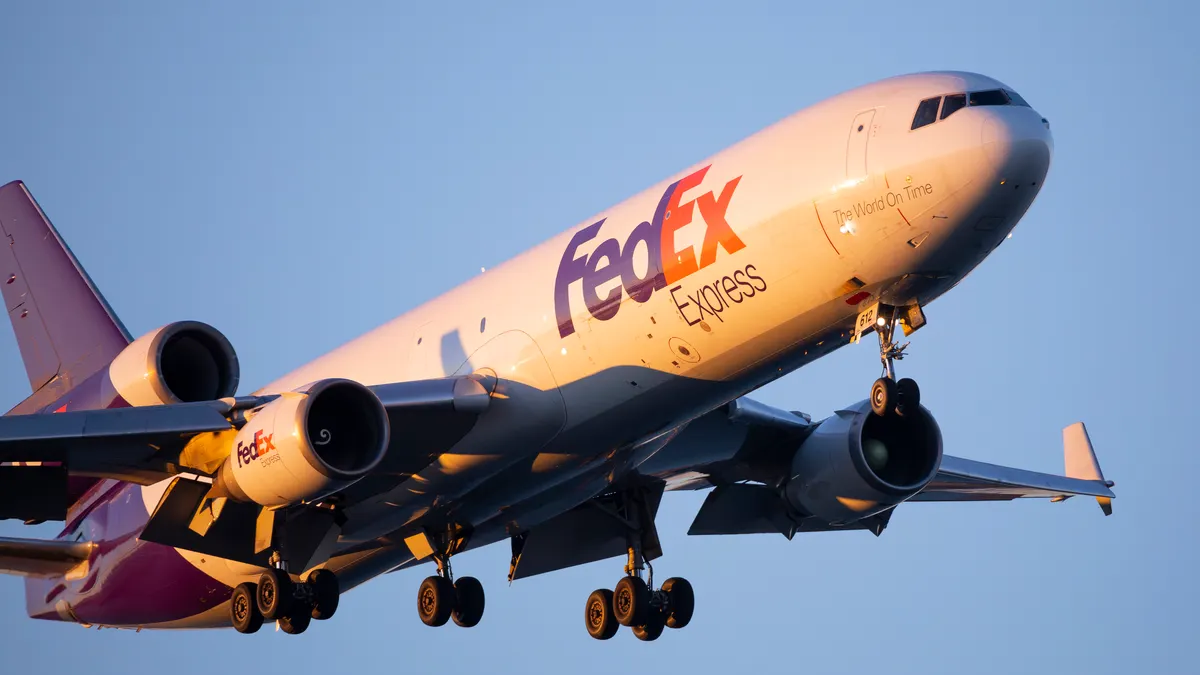 A white and purple FedEx Express branded aircraft in the sky