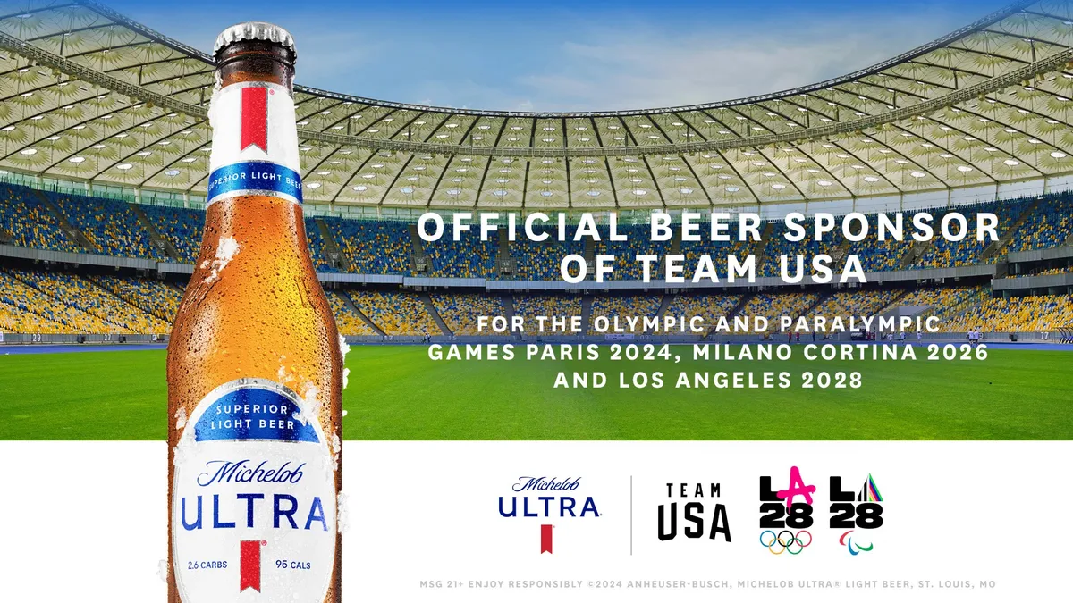 A bottle of Michelob Ultra in front of a sports field.