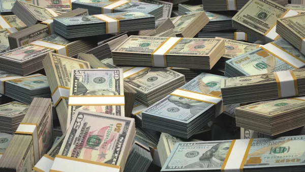 Stacks of U.S. fifty and one hundred dollar bills are shown.