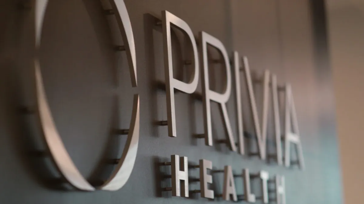 A side-angle view of metal letters hanging on a wall that make up the Privia Health logo