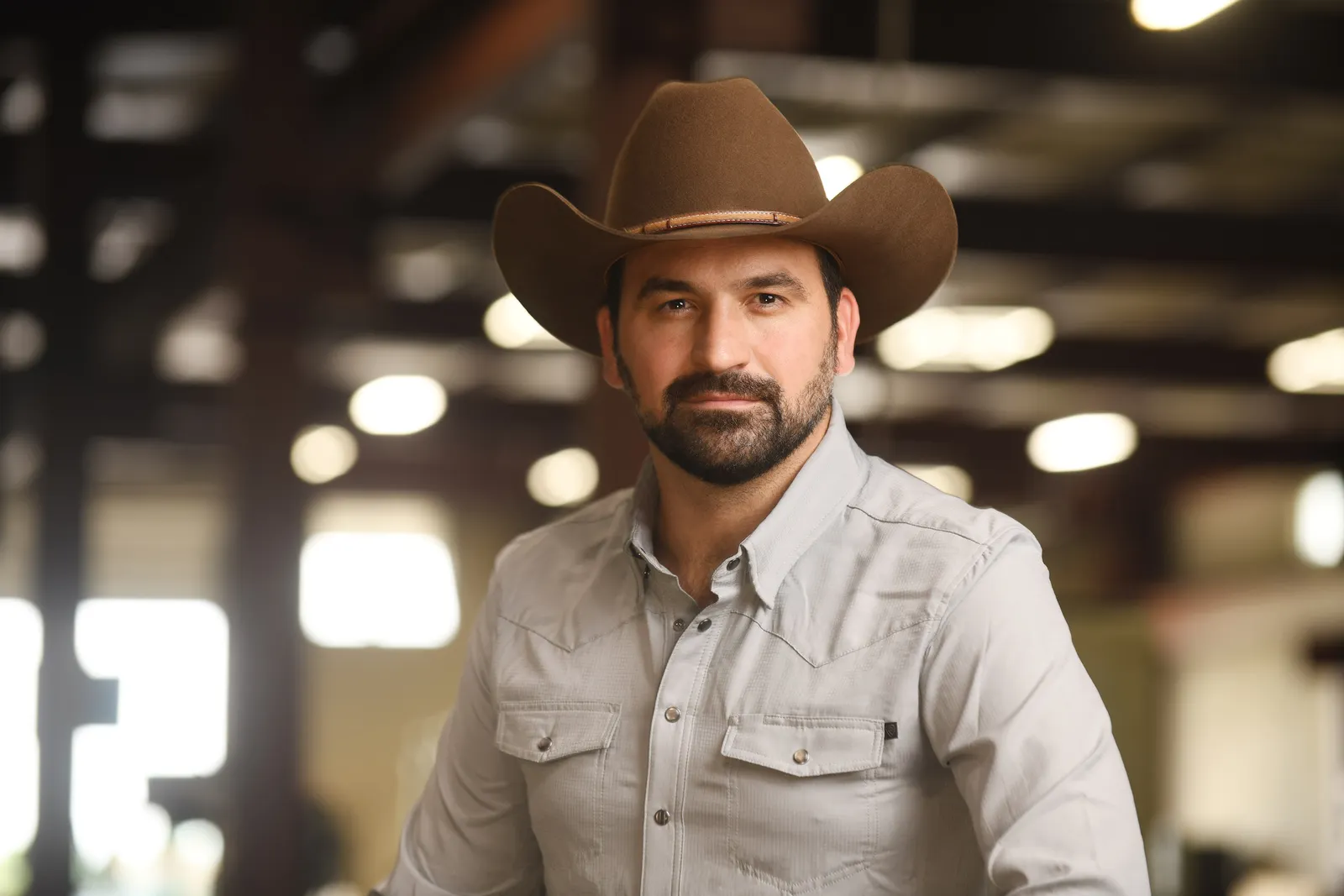 Jason Azevedo, chief strategy officer of the Manufacturing Revitalization Corporation of America, sits in a cowboy hat