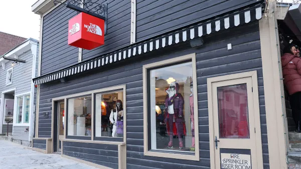 A North Face storefront. The sidewalk in front of it is covered in snow.