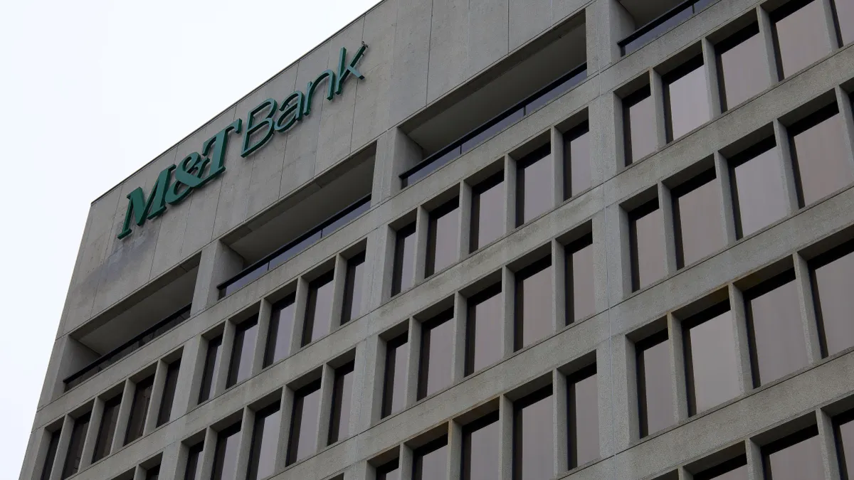 A brutalist-style commercial building containing grided dark windows has a large "M&T Bank" logo at the top corner of the building.