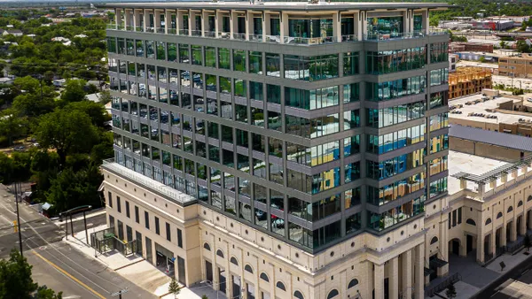 A stone-and-glass office building is shown from above.