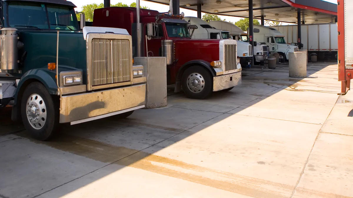 Several trucks at a rest stop gas station filling up tanks - stock photo