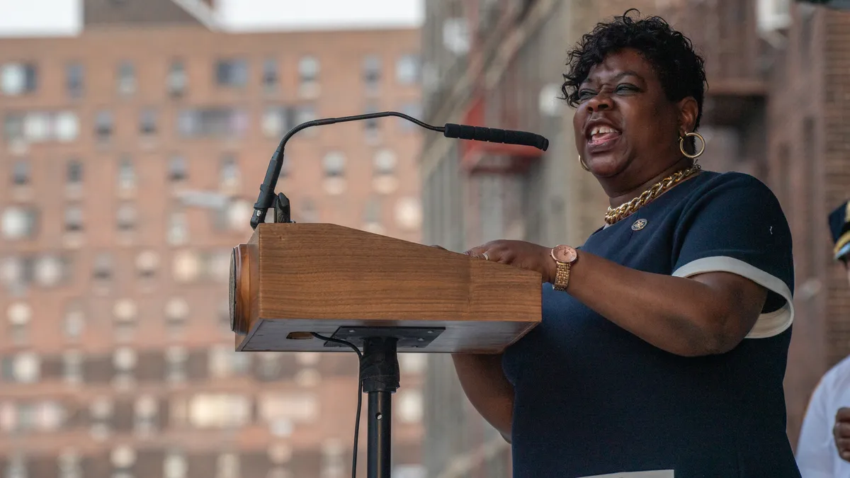 A woman delivering a speech at a podium.