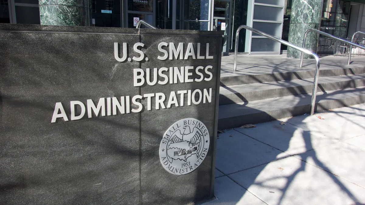 The office building has a 'U.S. Small Business Administration' sign above the entrance wall, next to short stairs with handrails leading to the entrance. 