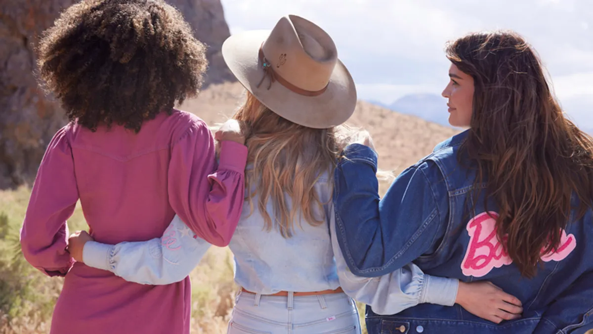 Three models wearing pieces from the Wrangler x Barbie collection.