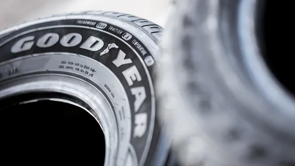 A black tire with the Goodyear logo on it.