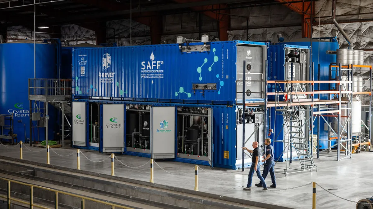 Workers walk by a PFAS treatment facility