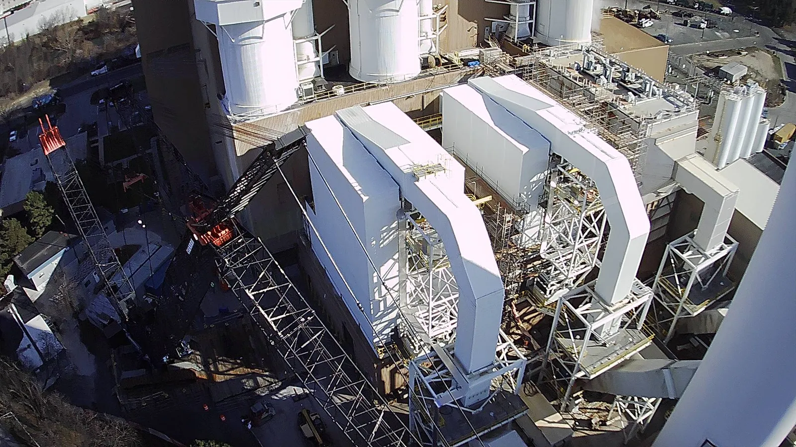 Aerial view of an industrial facility showing three similar-looking receptacles that are several stories tall.