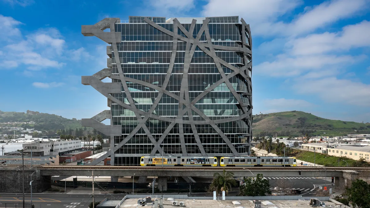 A building centered in the image with columns running all across the exterior. It stands large compared to the rest of the framing.