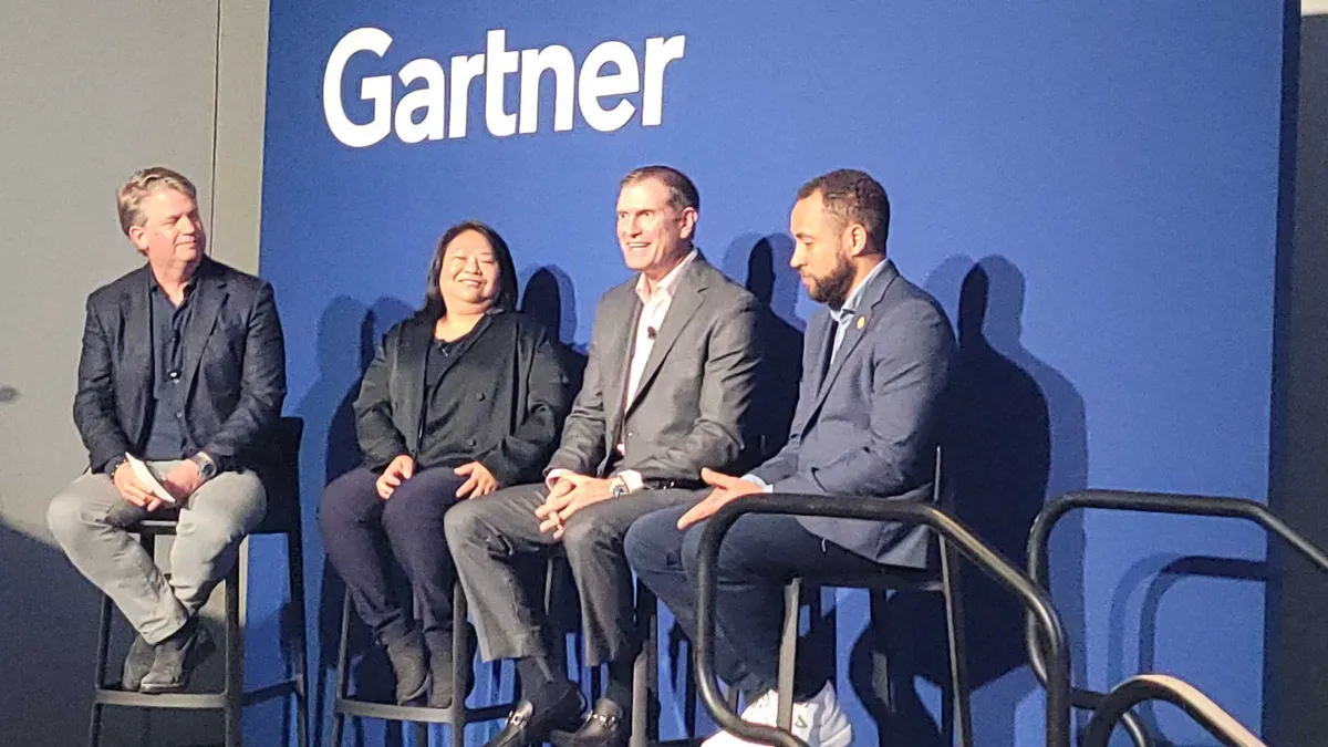 four executives speaking during a conference