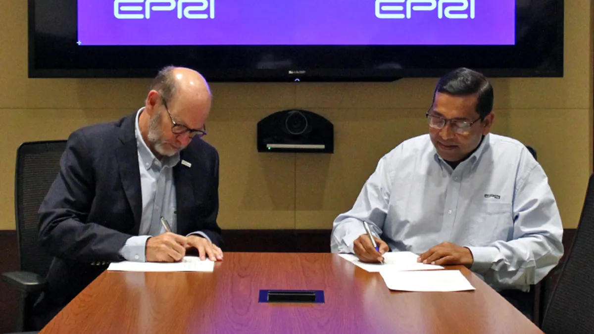 Jim Robb, president and CEO of the  North American Electric Reliability Corp., and Arshad Mansoor, president and CEO, Electric Power Research Institute, sign an MOU to collaborate on grid issues