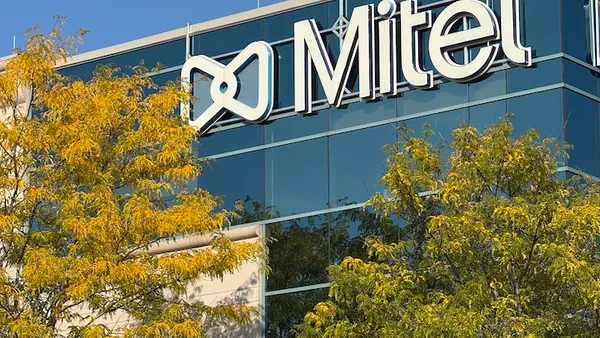 A large office building with the Mitel corporate log in view is pictured.