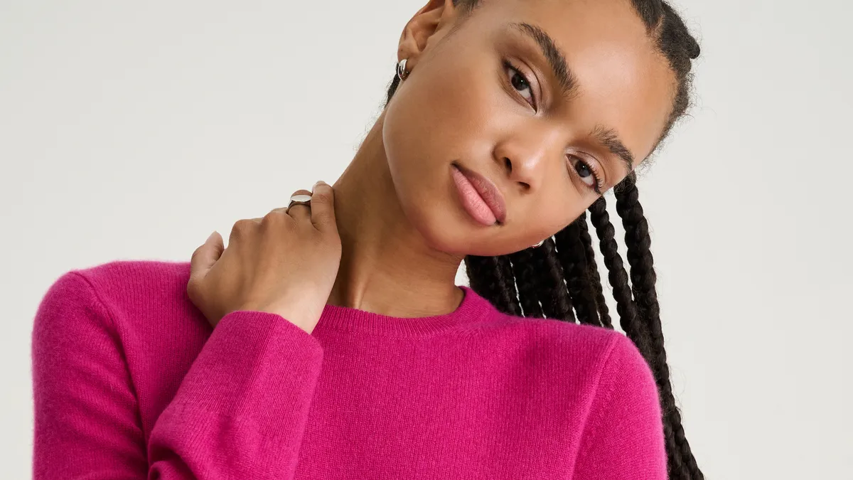 A person wearing a bright pink Naadam cashmere sweater from its "Soft Collection" at Kohl's