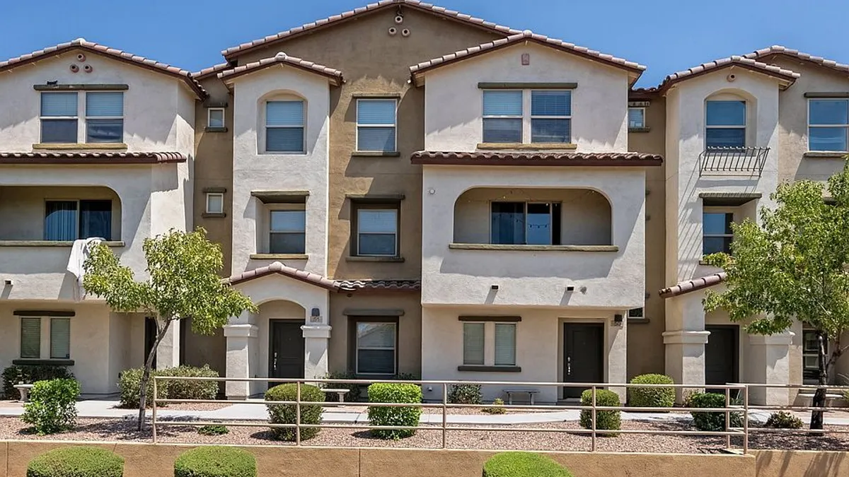 Front view of tan three-story apartment transaction.