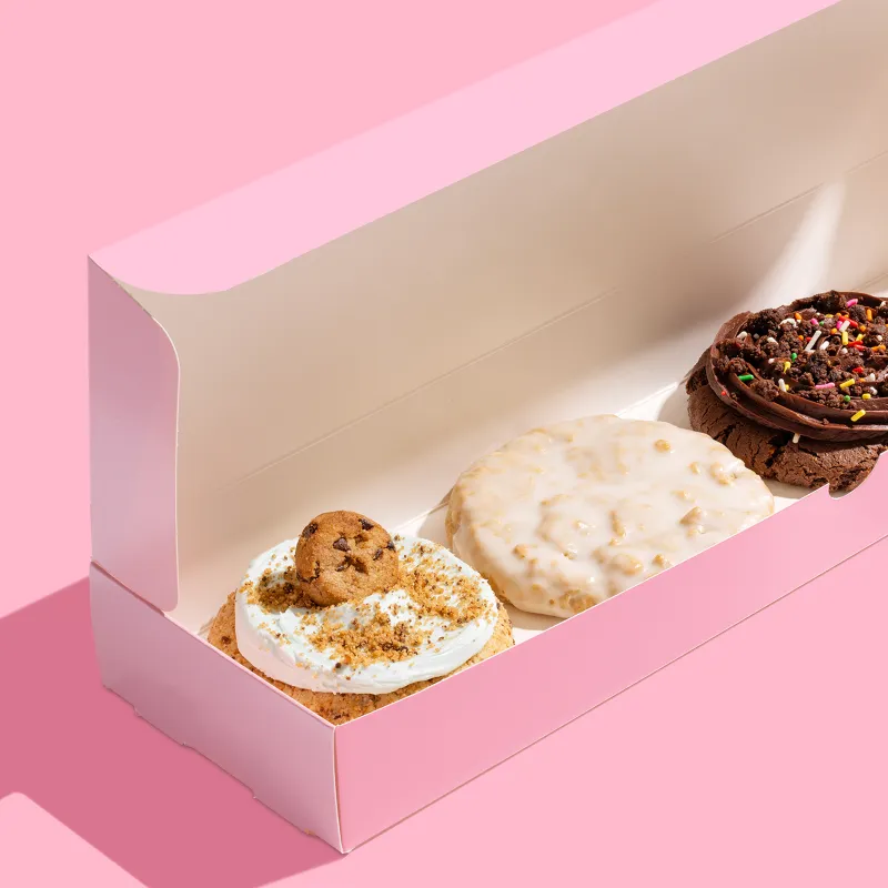 A pink box with four cookies inside from Crumbl