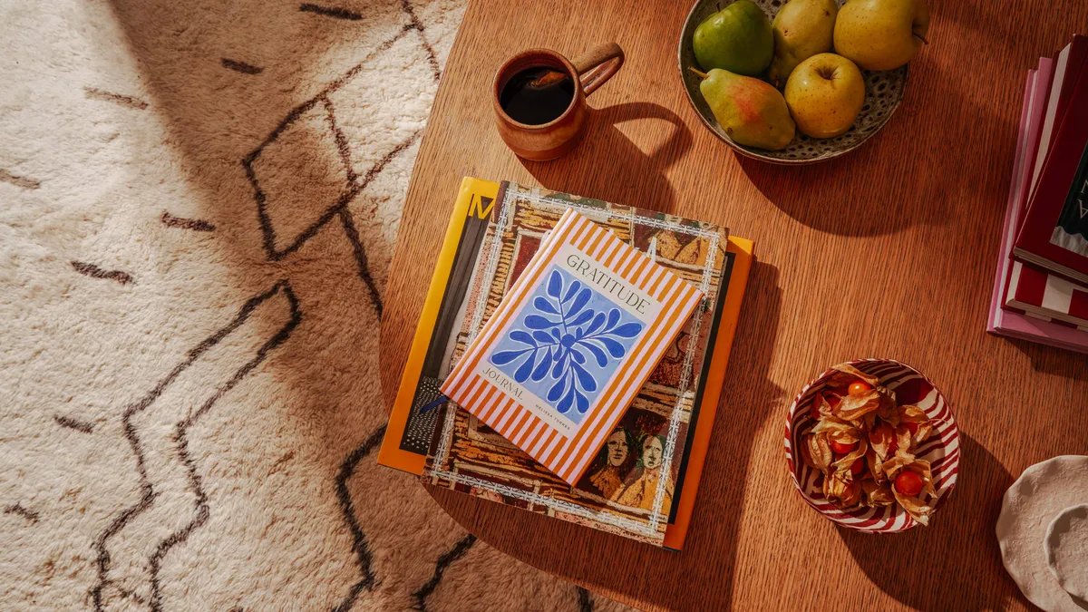 A stack of notebooks on a coffee table.