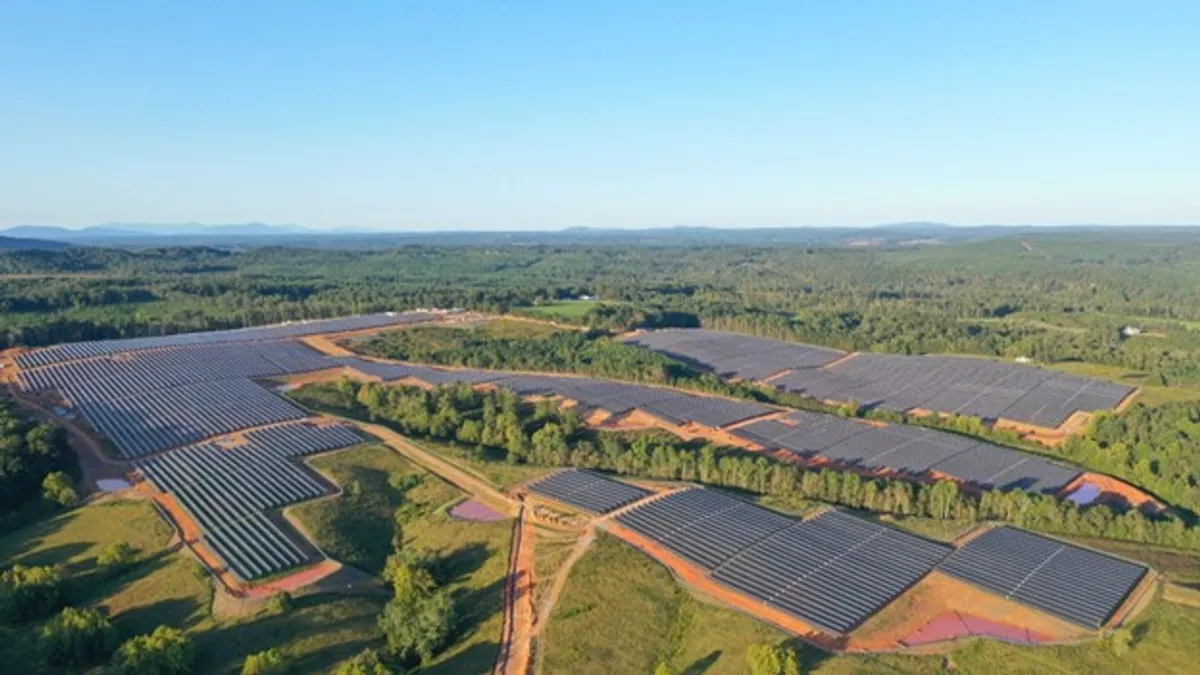 An aerial view of solar plant surrounded by greenery