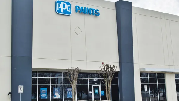 A beige building with glass doors and the blue and white PPG Paints logo near the top of the building.